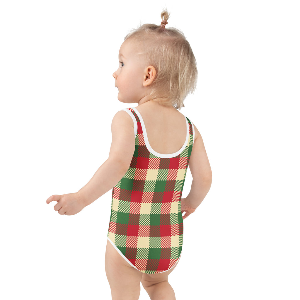A toddler wearing a girls christmas plaid buttery soft red green cream swimsuit with white trim and upf 50 plus