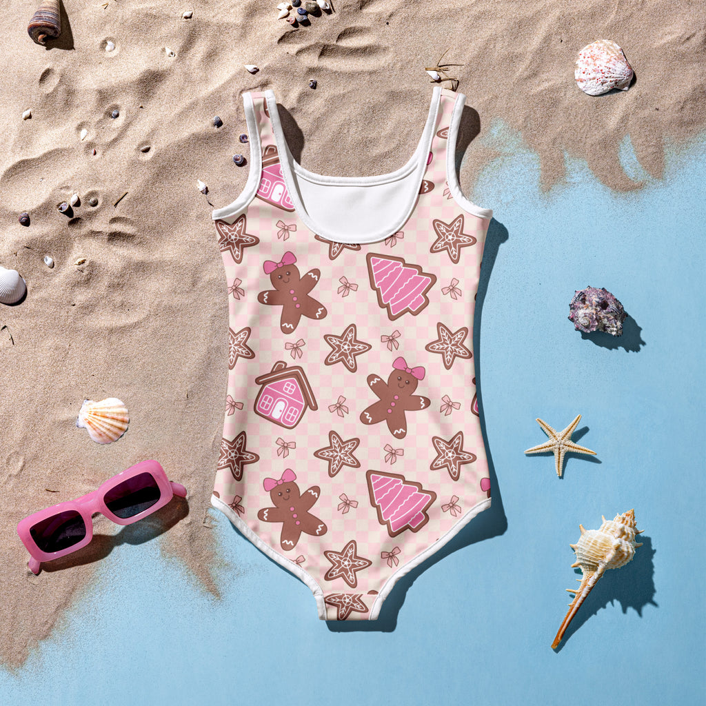 Girls pink gingerbread buttery soft one-piece swimsuit with white trim and festive patterns and upf 50+ protection