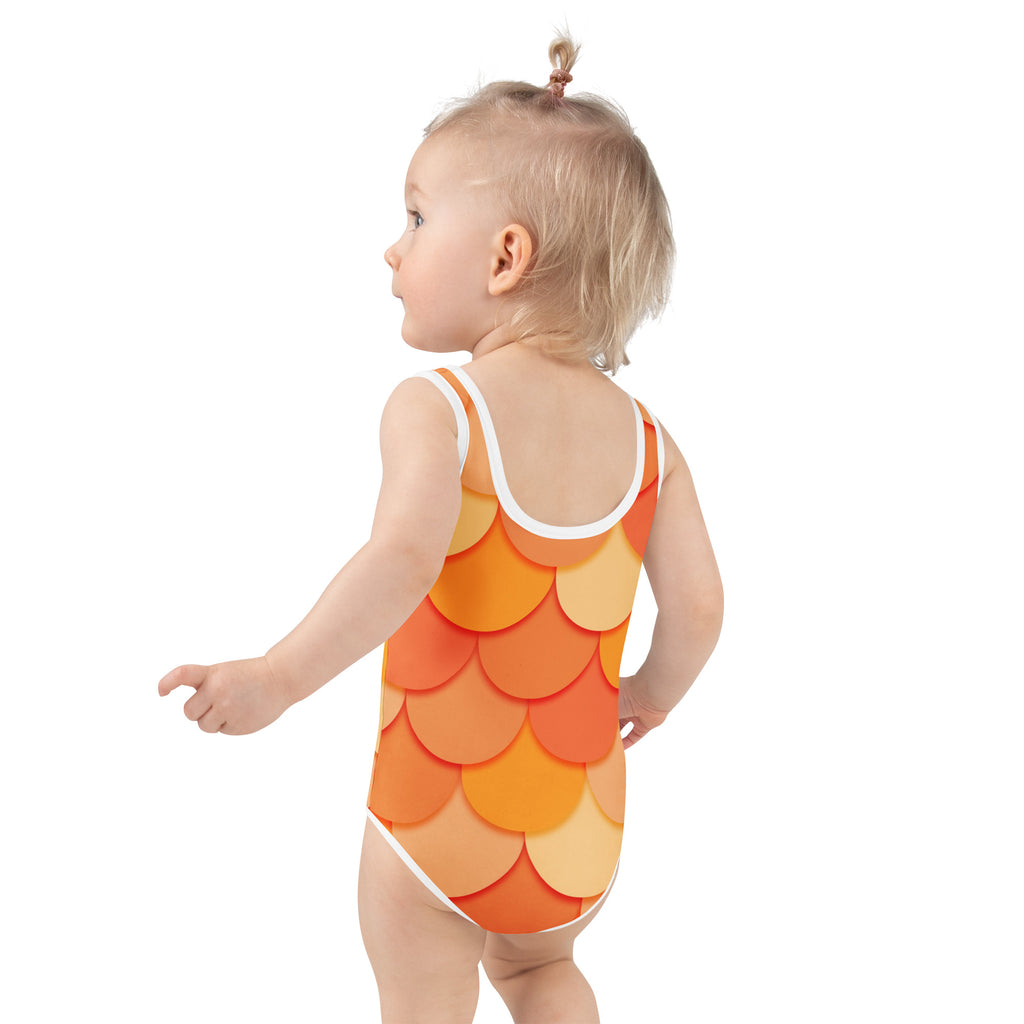 A toddler wearing a girls orange mermaid buttery soft swimsuit with orange and yellow fish-scale pattern and UPF 50+