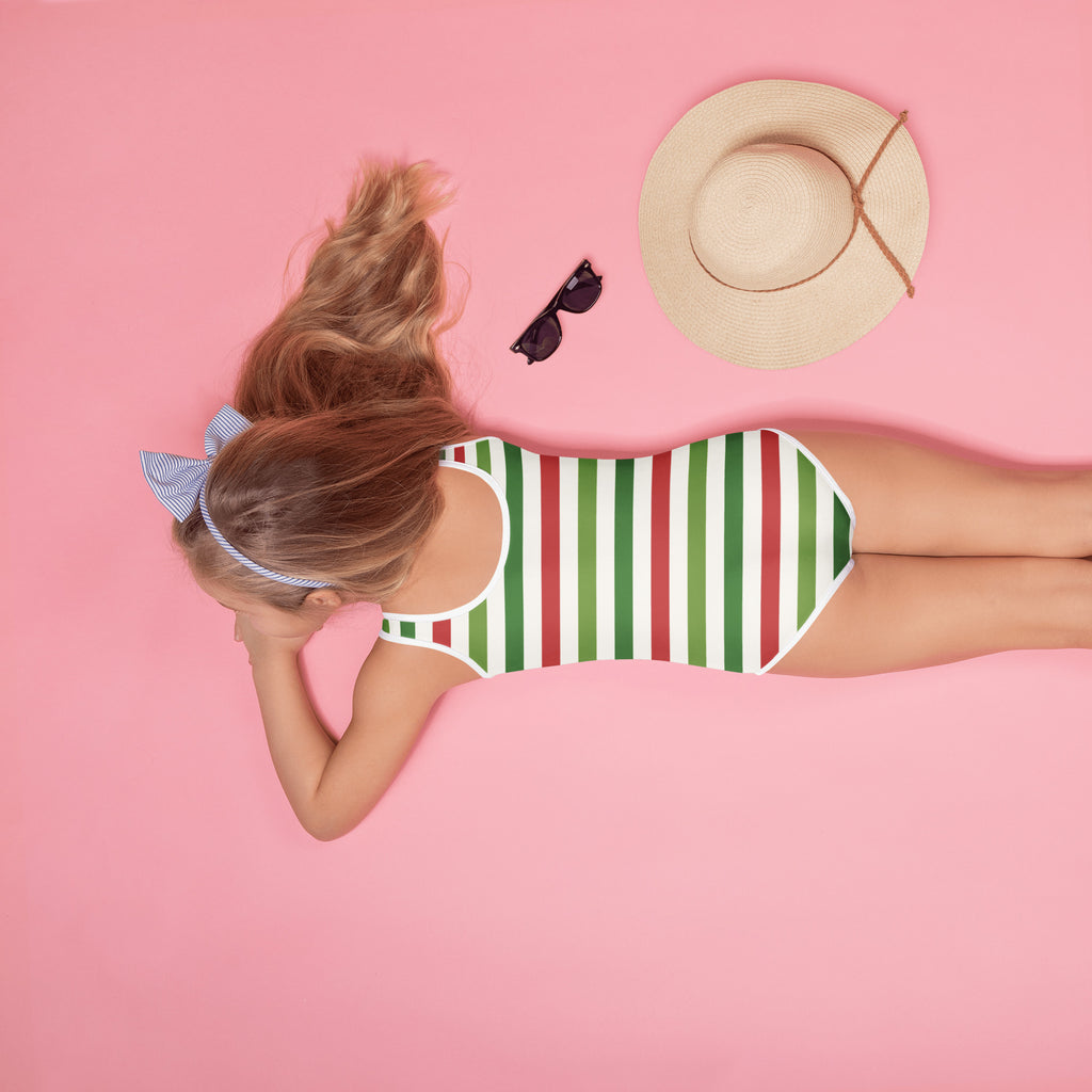 A girl wearing a girls striped Christmas buttery soft one-piece swimsuit with UPF 50+ and a blue-and-white headband