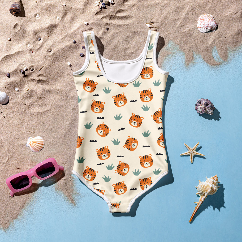 A cream-colored girls one-piece swimsuit with orange tiger faces green cactus prints white trim and UPF 50+ buttery soft fabric