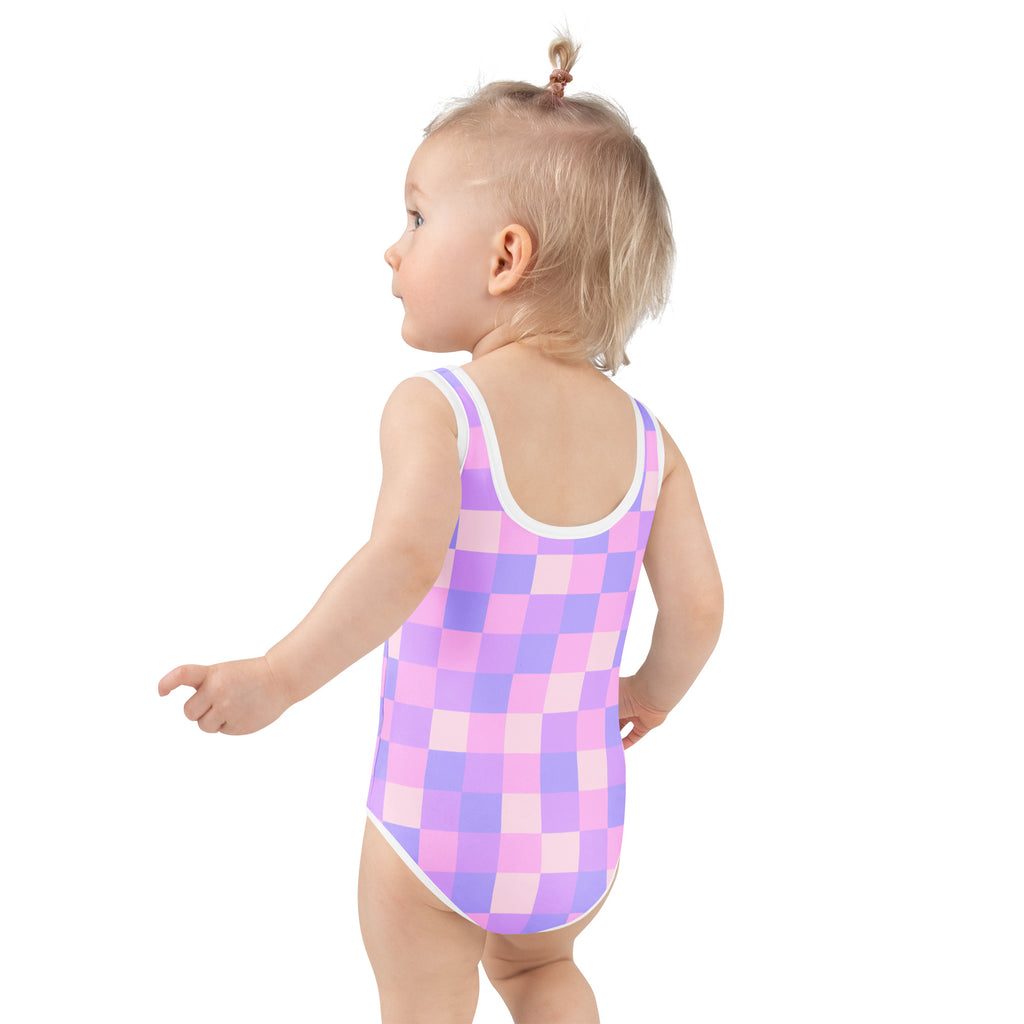Toddler girls one-piece swimsuit in pastel pink and lavender checkerboard with white trim made from buttery soft fabric with upf 50+