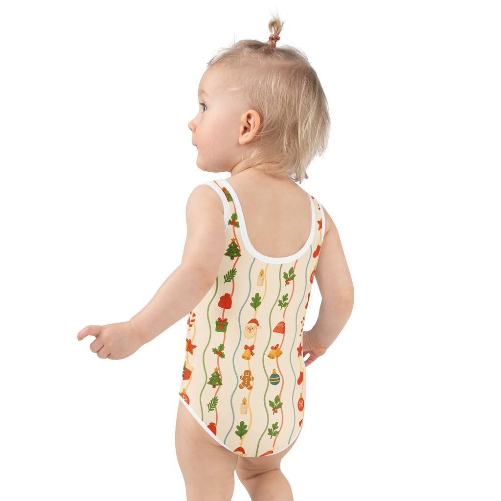 A child wearing a cream girls christmas garland buttery soft swimsuit with colorful holiday illustrations and upf 50+ protection