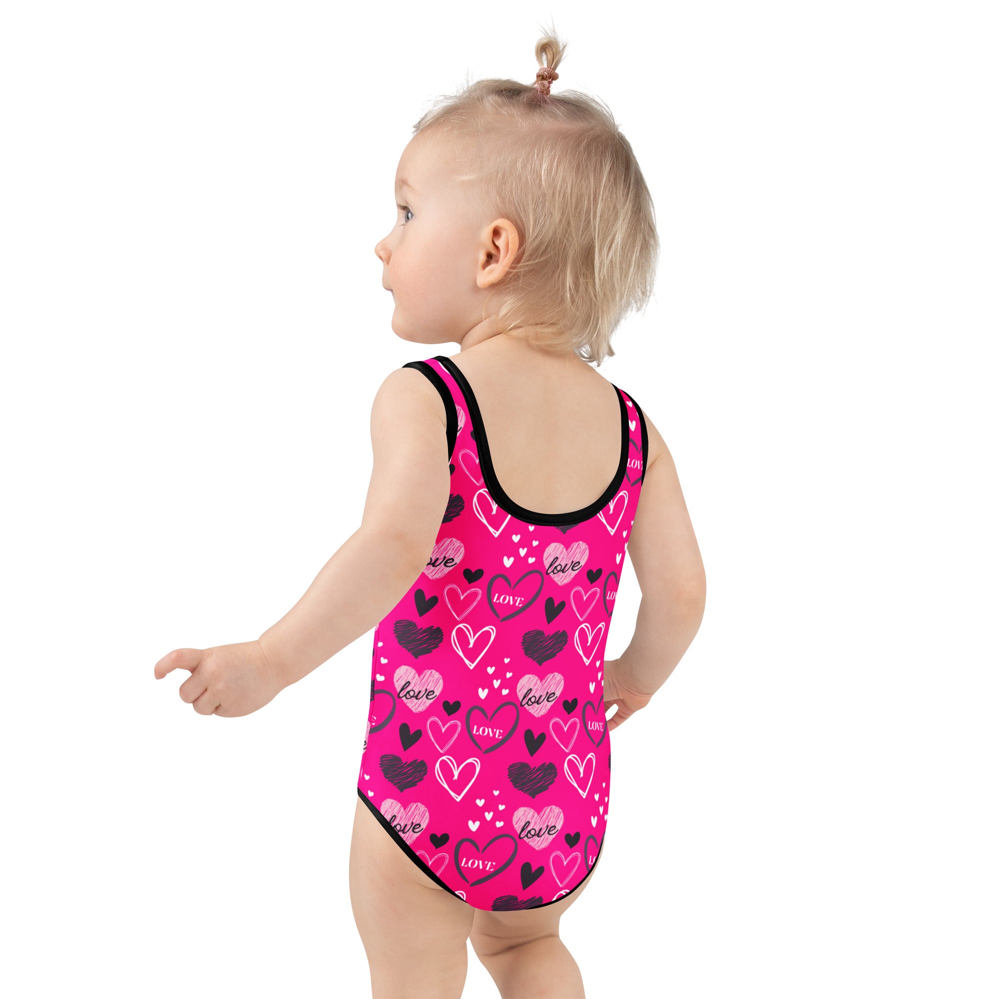 Girls valentine’s day pink heart buttery soft swimsuit with black trim and upf 50 plus protection in playful pattern