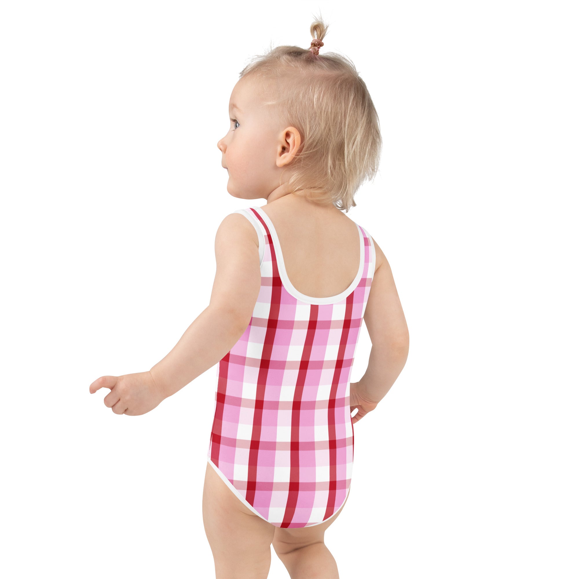 A toddler wearing a pink and white checkered girls valentine’s day gingham buttery soft swimsuit with upf 50 plus
