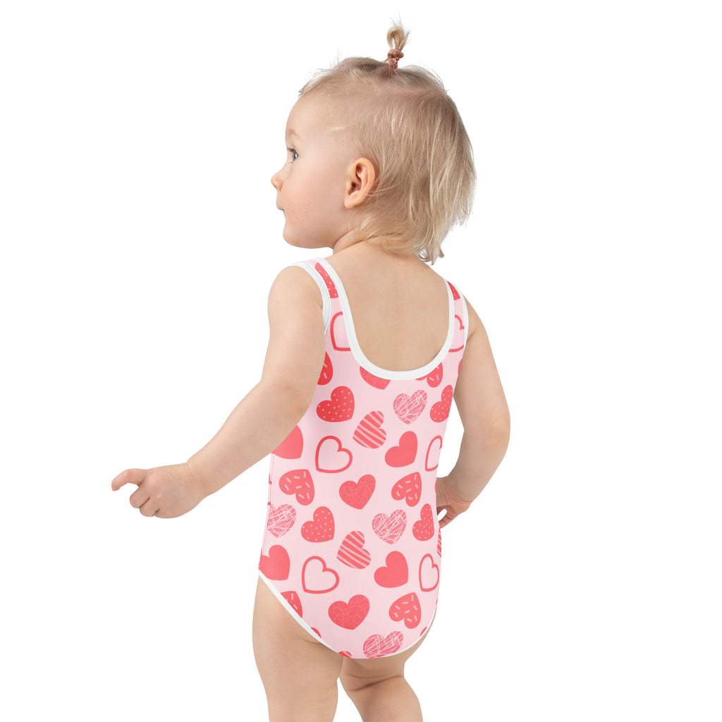 Girls pink heart pattern buttery soft swimsuit with white trim and upf 50 plus double layered front
