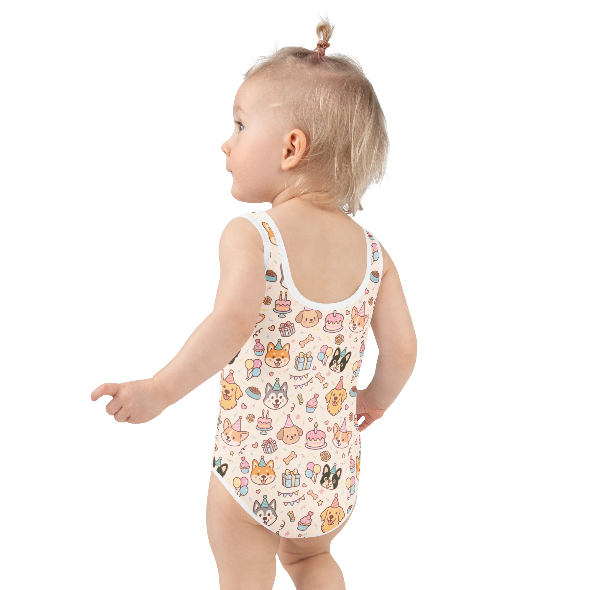 A child wearing a cream girls puppy birthday buttery soft swimsuit with upf 50 and cartoon dog party print