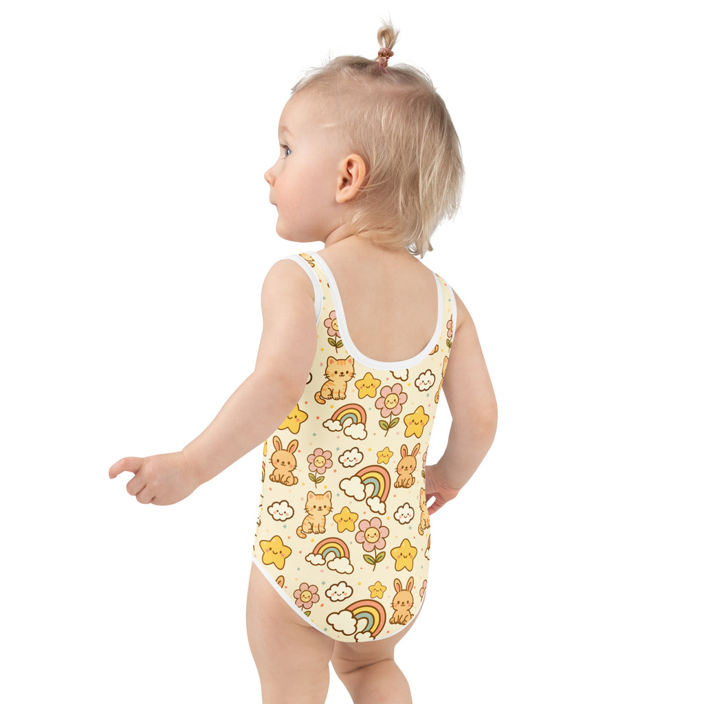 A child wearing a cream-colored girls bunnies cats and rainbows buttery soft swimsuit with upf 50 and double layered front