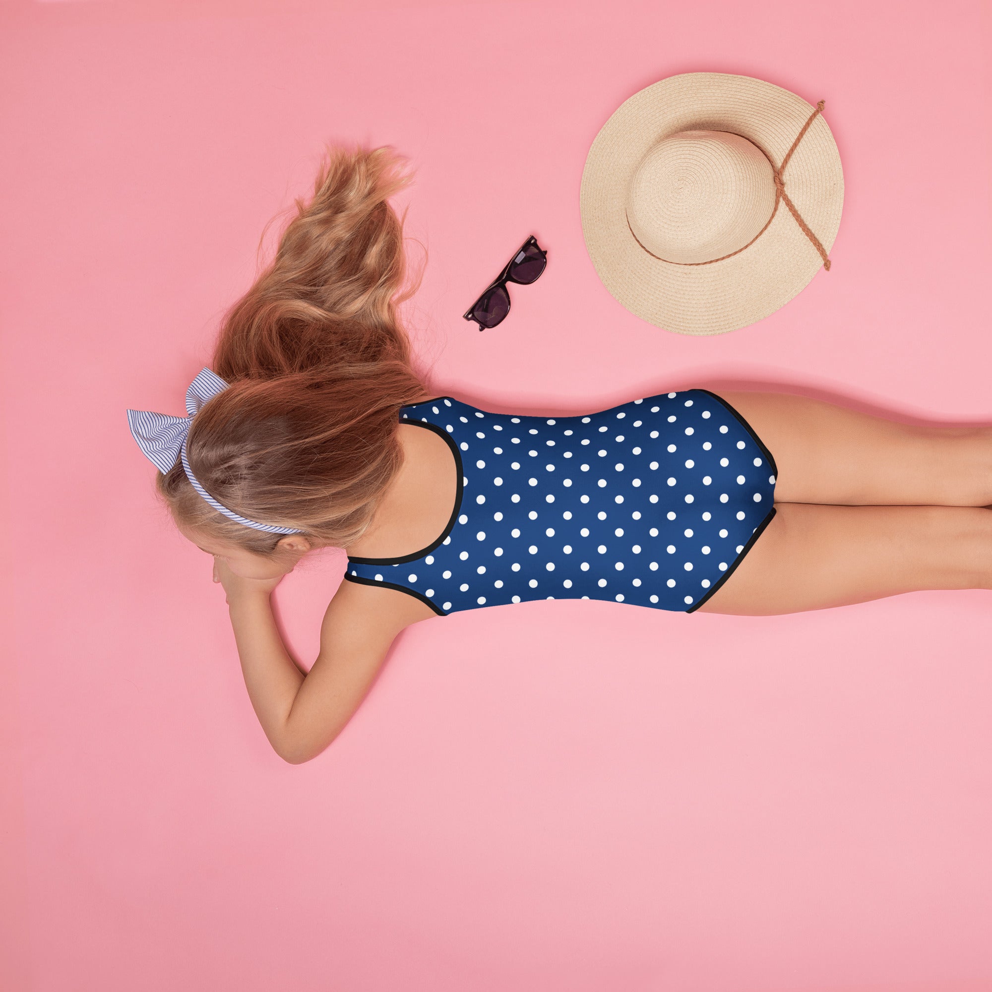 Girls dark blue polka dot buttery soft one-piece swimsuit with black trim and upf 50 plus double layered front