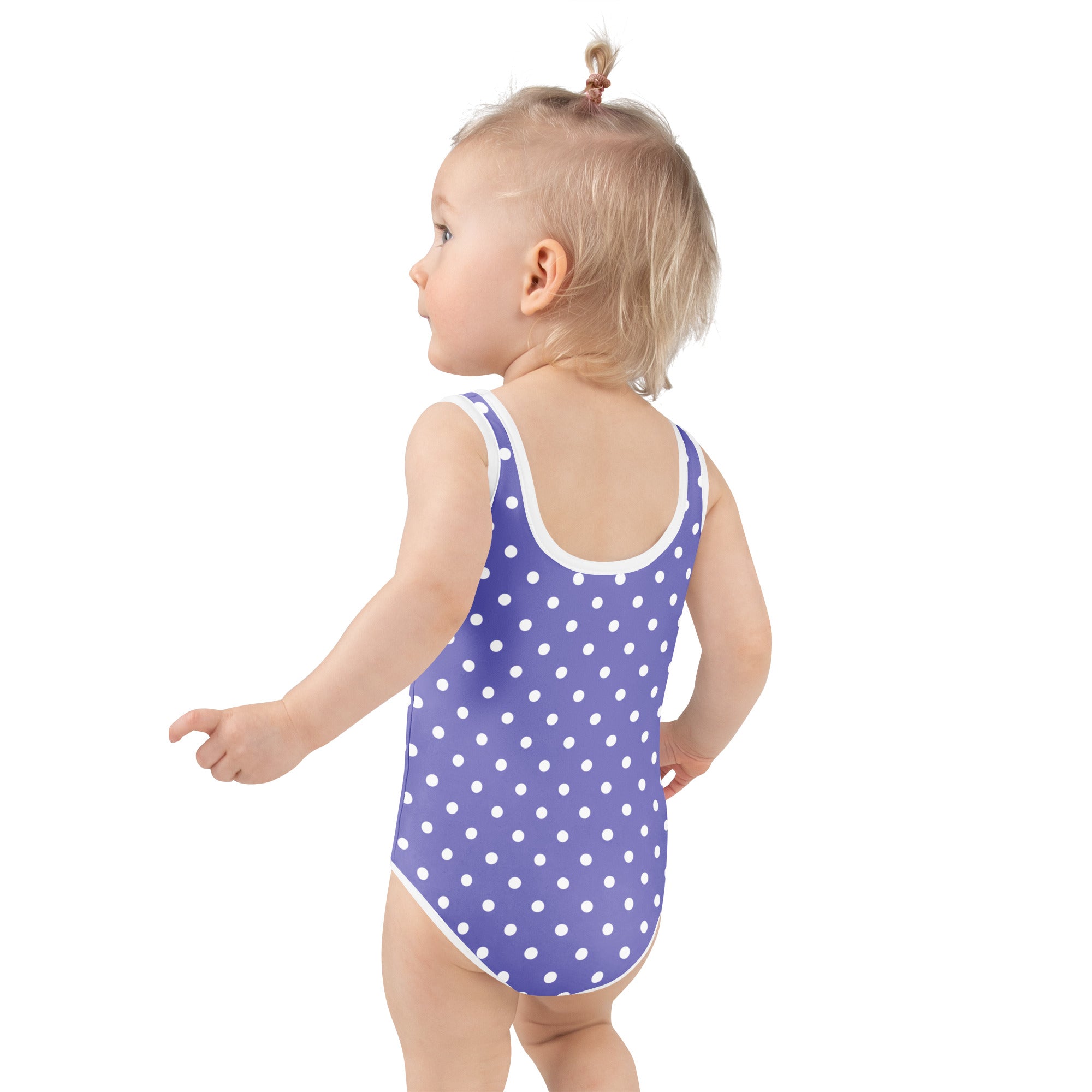 A toddler wearing a girls purple polka dot buttery soft swimsuit with UPF 50 plus and double layered front