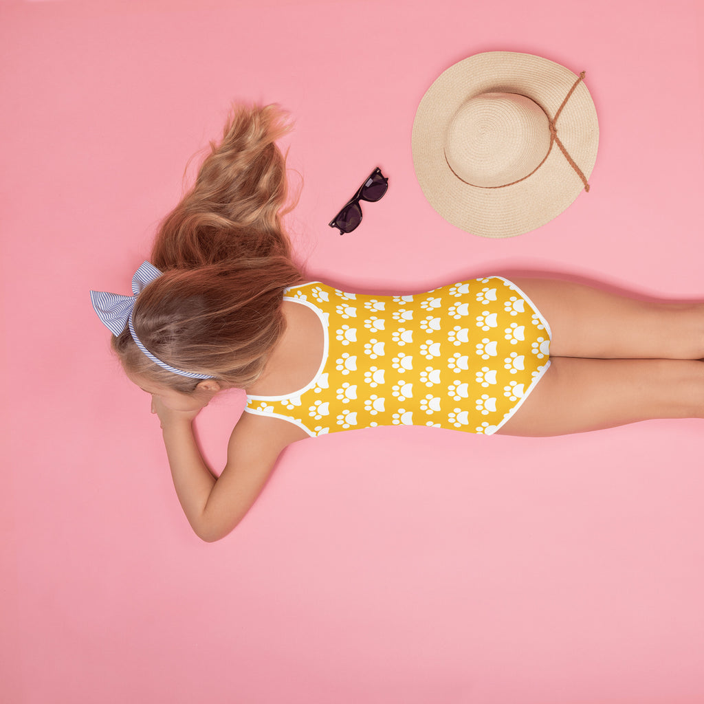Girls yellow one-piece swimsuit with white paw print pattern and trim made of buttery soft fabric upf 50 plus