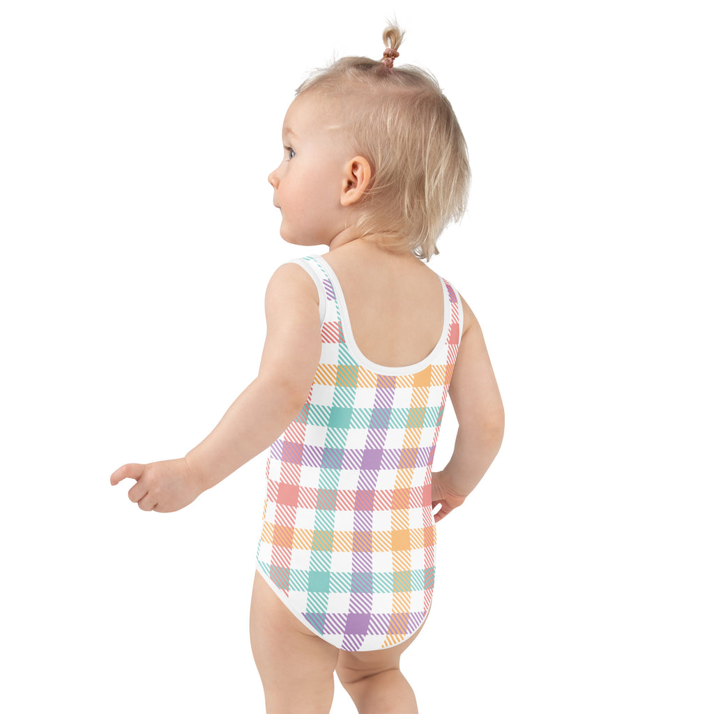 A toddler wearing a girls pastel rainbow gingham buttery soft one-piece swimsuit with upf 50 and double layered front