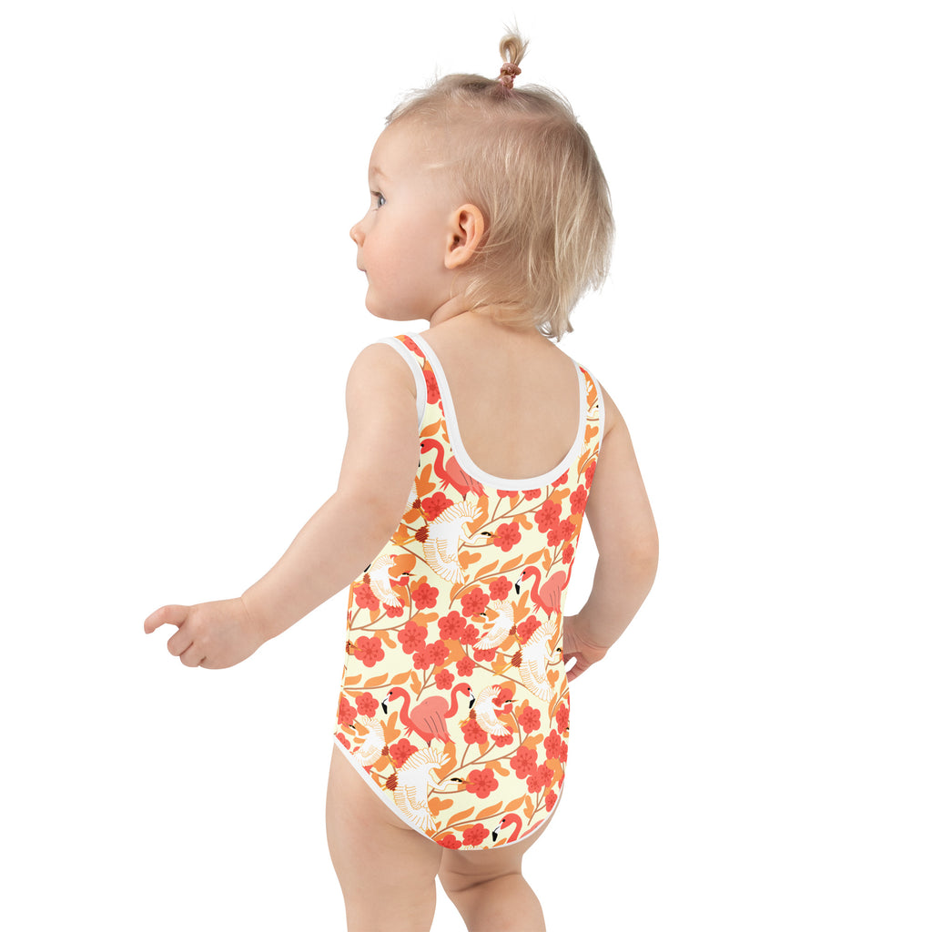 A toddler wears a girls floral flamingo and pelican buttery soft swimsuit with upf 50 plus double layered front