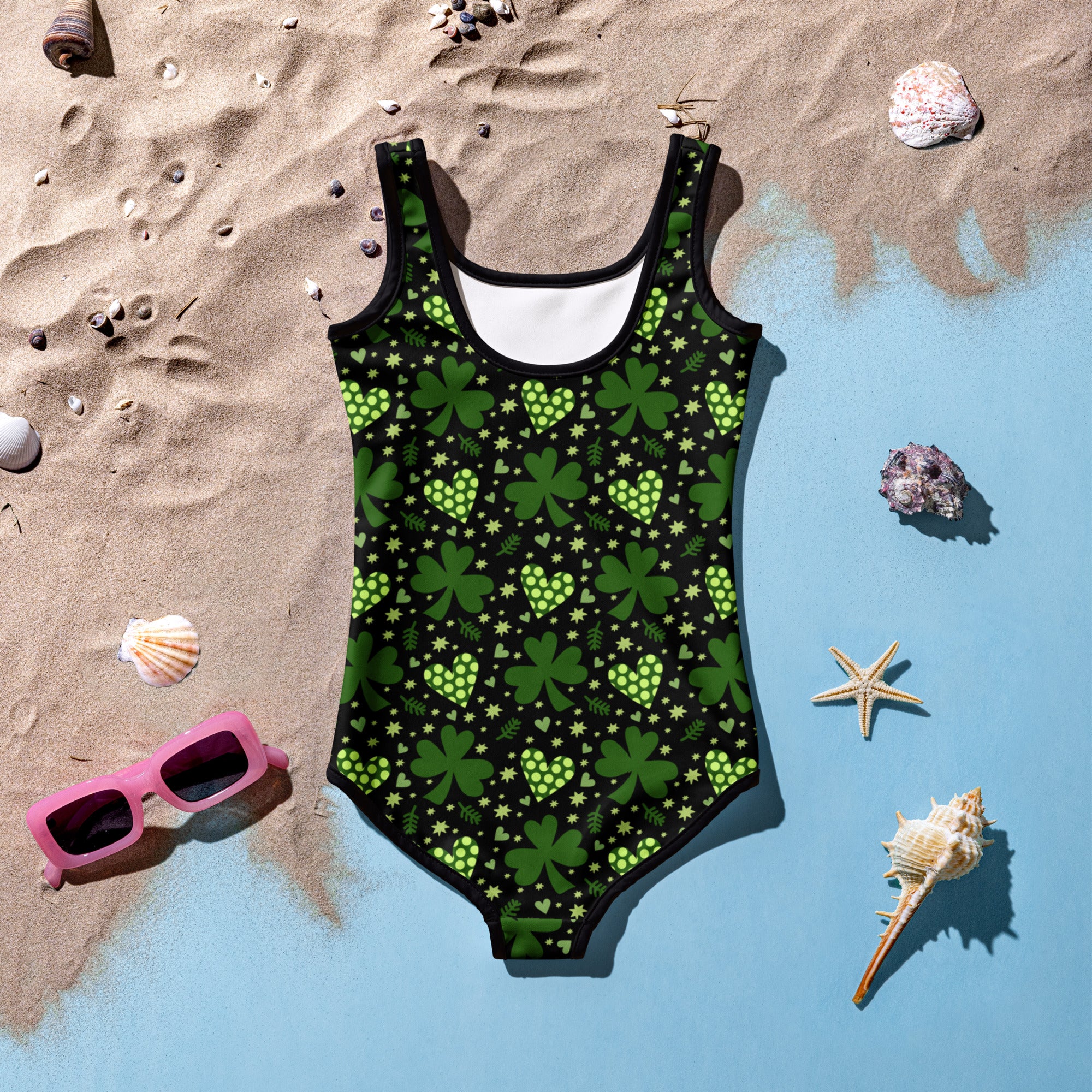 A vibrant green girls one-piece swimsuit with shamrock heart and star pattern on black, buttery soft fabric with UPF 50+ and double layered front
