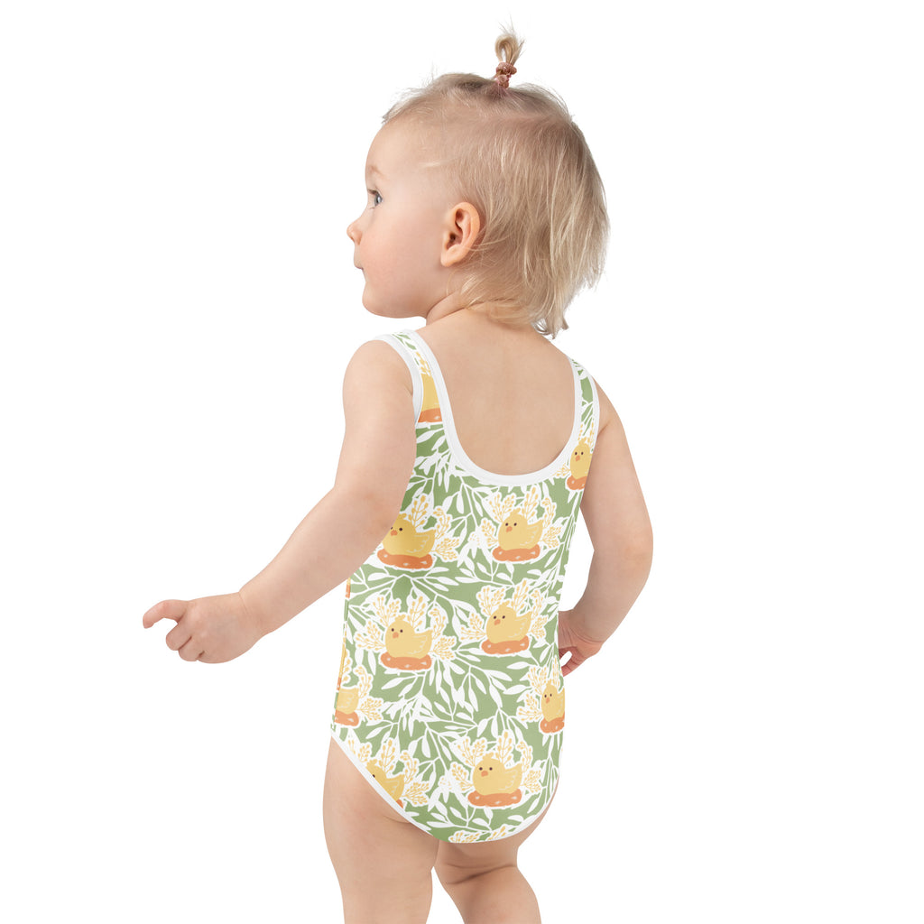 A child wearing a green and white girls spring chick buttery soft swimsuit with yellow duck pattern and UPF 50+ protection
