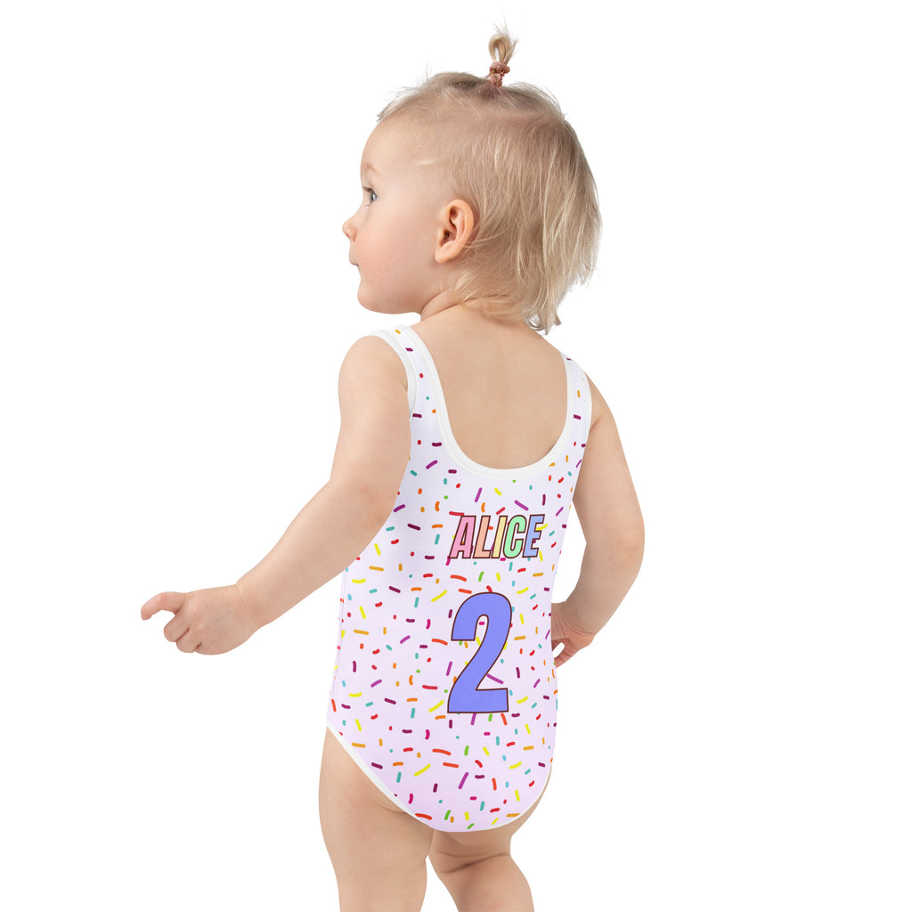Child wearing a swimsuit with colorful sprinkles and 'ALICE 2' text on a white background