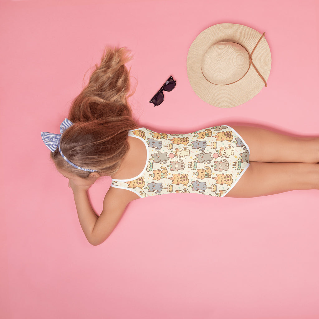 Person wearing a patterned swimsuit on a pink background with a hat and sunglasses.