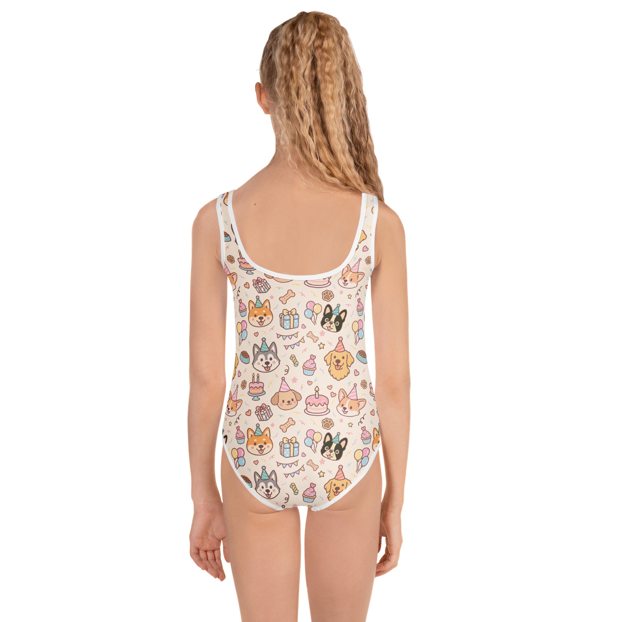 Child wearing a one-piece swimsuit with cartoon dog designs on a white background