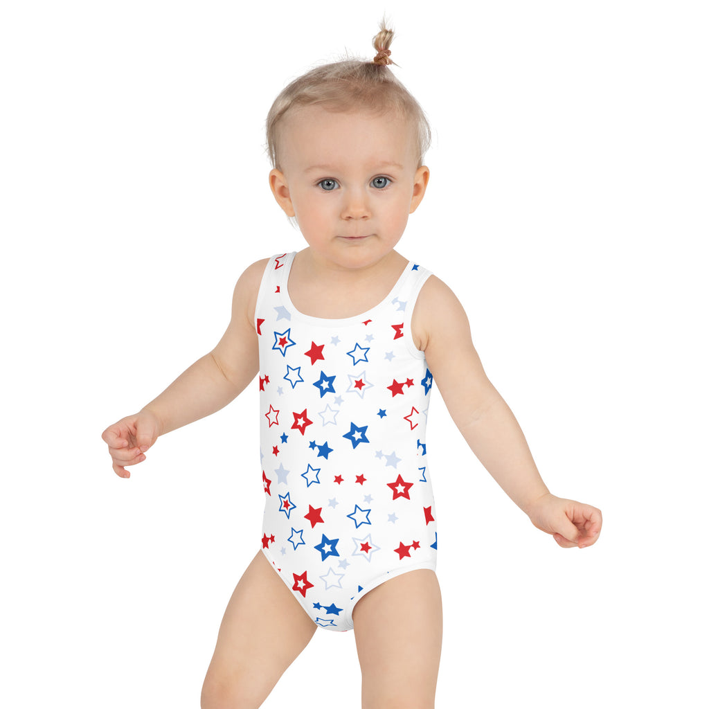 White one-piece swimsuit for girls featuring a playful red blue and silver star pattern for 4th of july wear