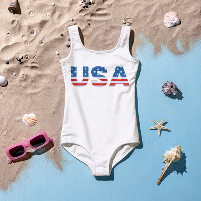 White one-piece girls swimsuit with usa printed in red white and blue flag design for 4th of July celebration