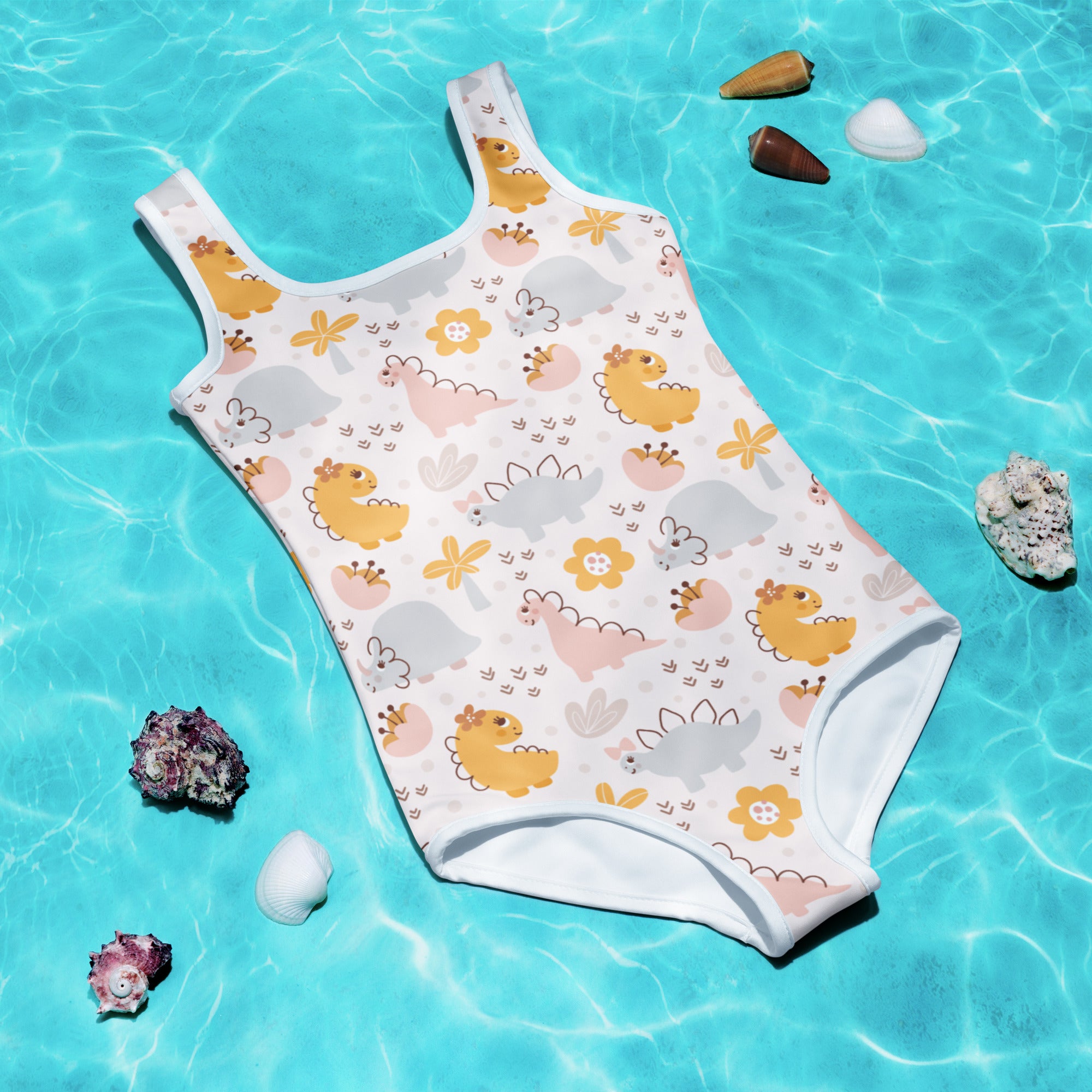 A white girls one-piece swimsuit with yellow pink and gray dinosaur pattern and small flowers with UPF 50+ protection