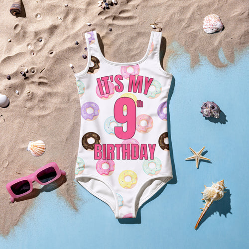White one-piece swimsuit with colorful donut patterns and pink it’s my 9th birthday text for girls birthday use