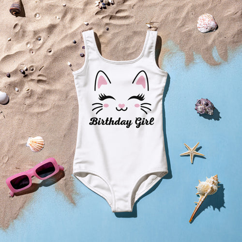 White one-piece girls swimsuit with cute cartoon cat face and birthday girl text in black cursive lettering