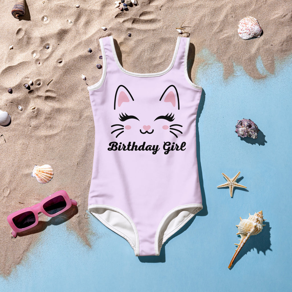 Girls cute cat birthday girl swimsuit in light pink one-piece with white trim and cat face design with closed eyes and rosy cheeks