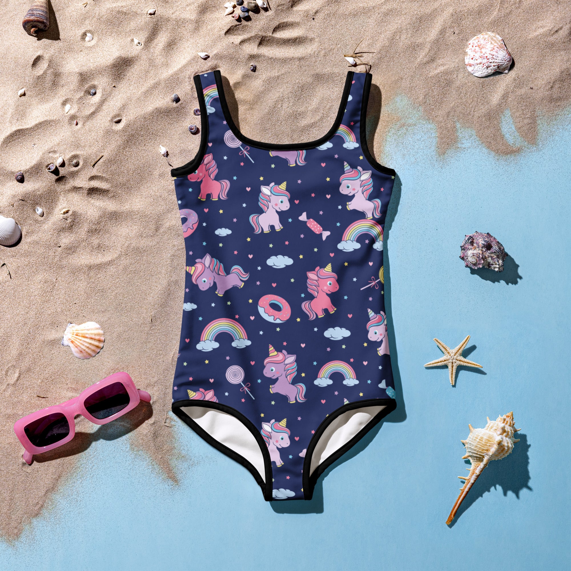 A navy blue girls one-piece swimsuit with playful pink and purple unicorns rainbows and upf 50 buttery soft fabric