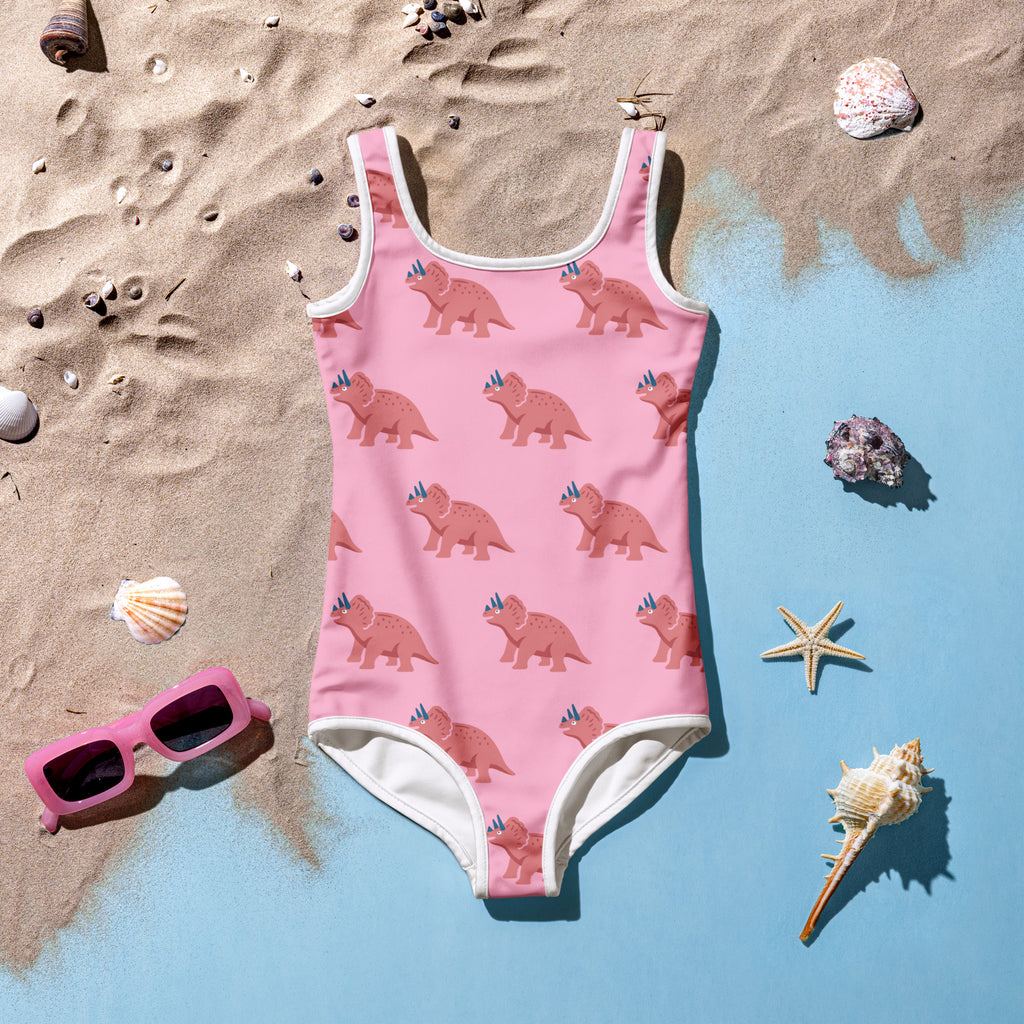 Girls pink triceratops buttery soft one-piece swimsuit with light pink dinosaur pattern white trim and UPF 50 plus protection
