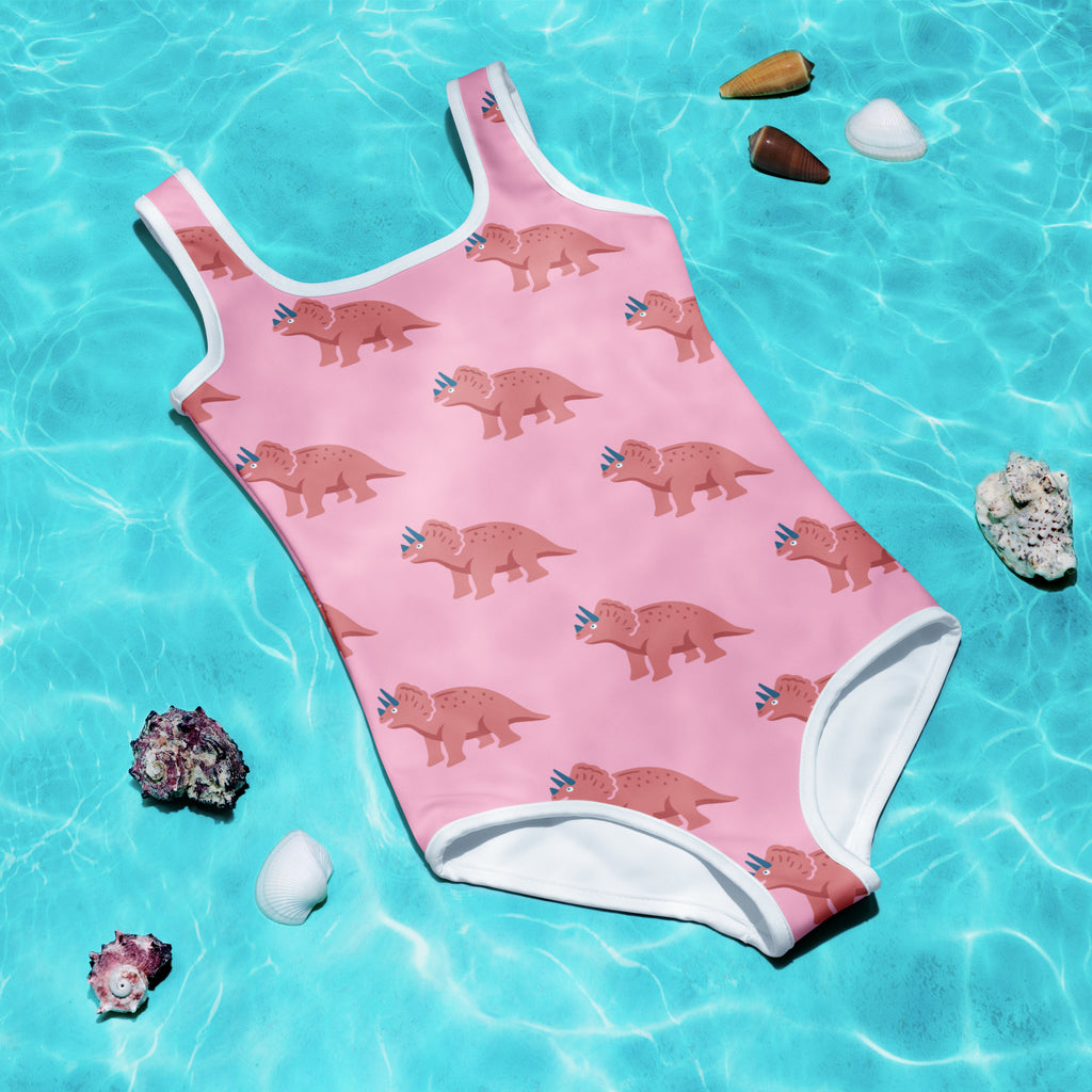 Girls pink buttery soft swimsuit with brown triceratops pattern white trim and UPF 50 plus sun protection