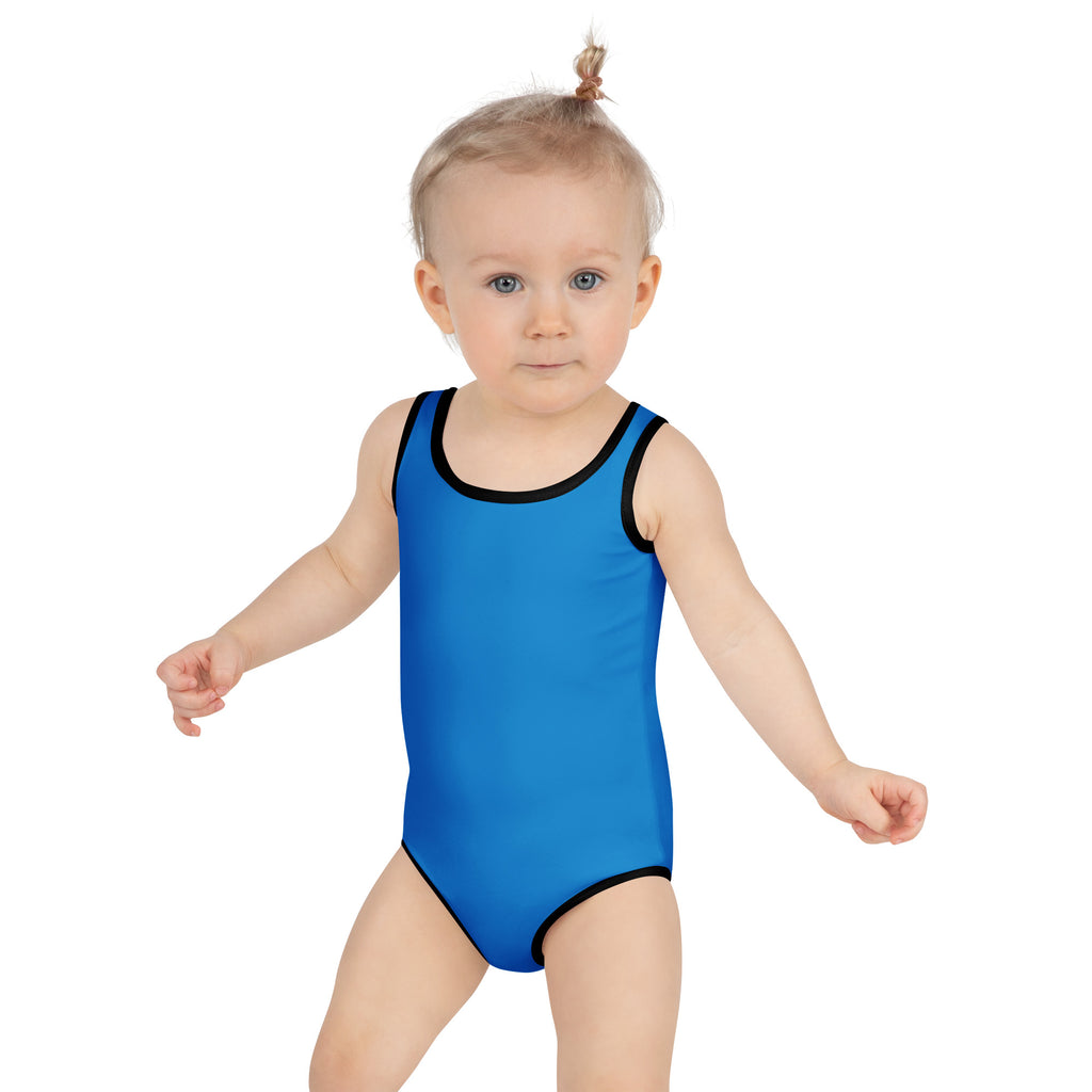 A toddler wearing a girls royal blue buttery soft swimsuit with black trim and UPF 50 plus sun protection