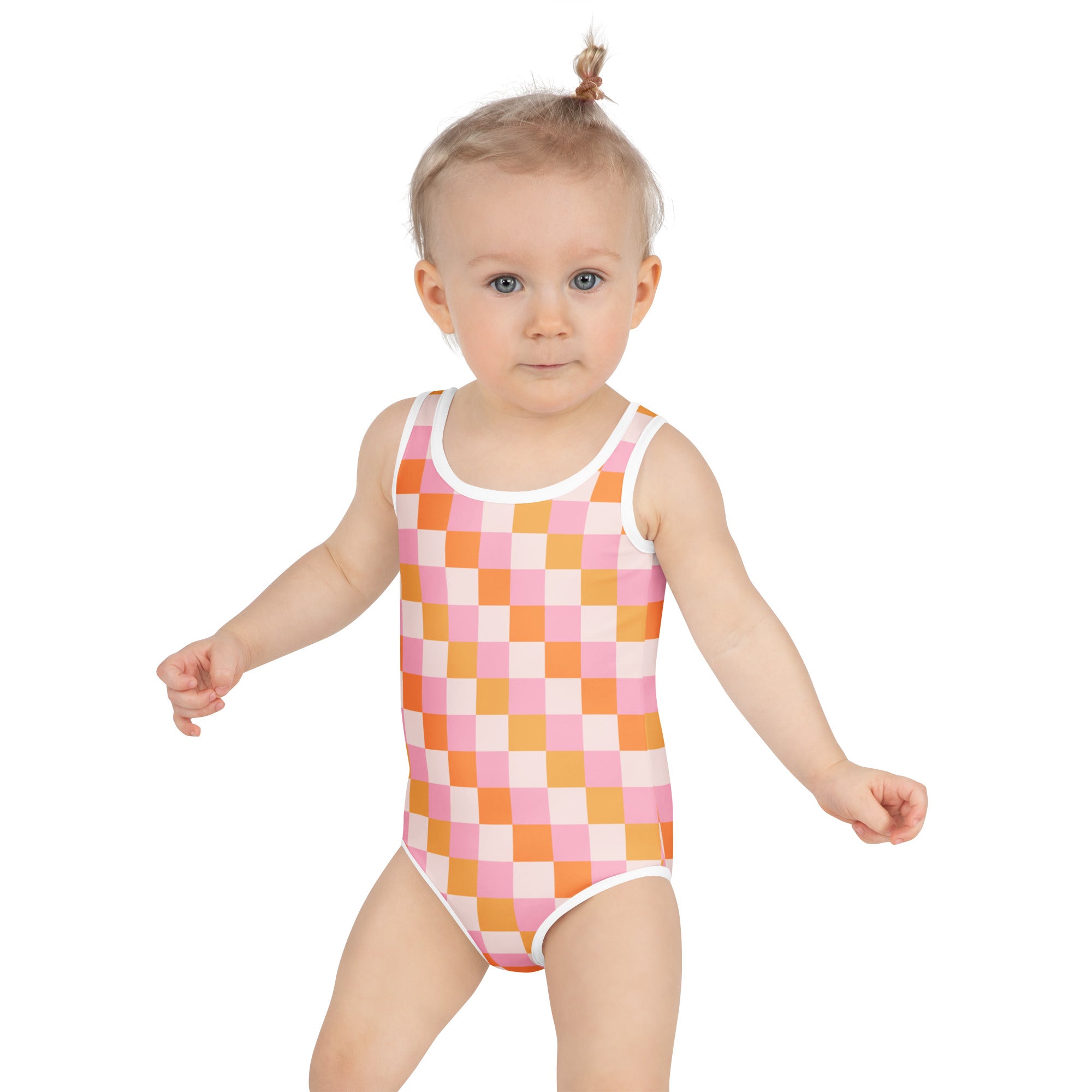 A toddler wearing a girls pink and orange checkered buttery soft one-piece swimsuit with upf 50 plus and white trim