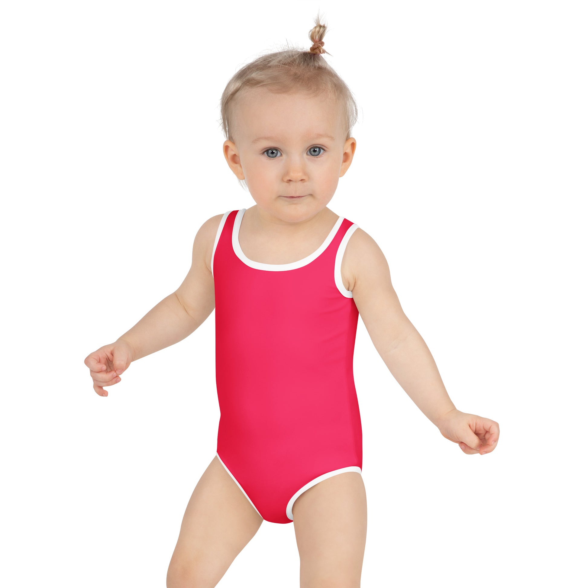 Toddler wearing a crimson pink swimsuit with white trim on a white background