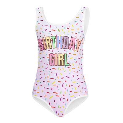 A white one-piece buttery soft leotard with colorful sprinkles and birthday girl in rainbow letters for dance and gymnastics