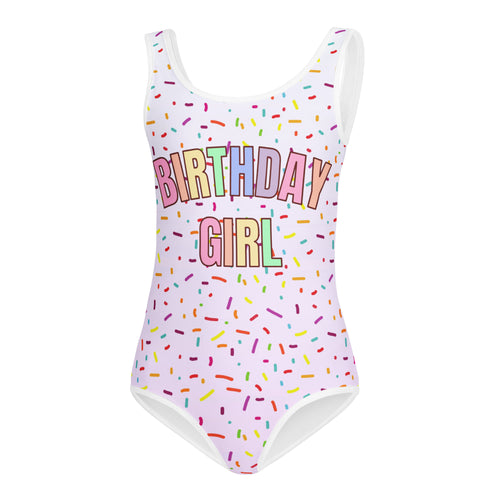 A white one-piece buttery soft leotard with colorful sprinkles and birthday girl in rainbow letters for dance and gymnastics