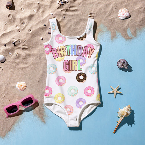White one-piece swimsuit with colorful donut birthday girl graphic made of buttery soft fabric for festive swimwear