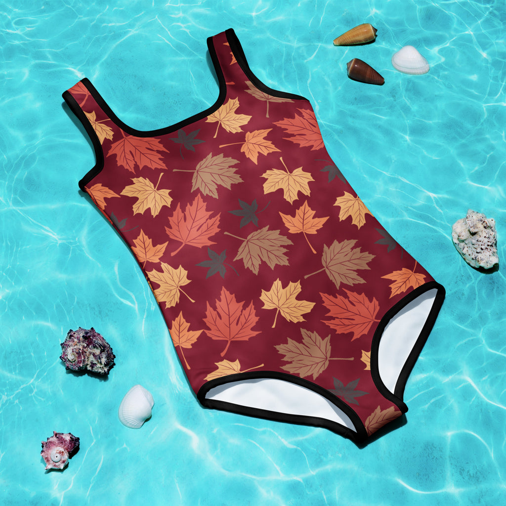 One-piece swimsuit with autumn leaf pattern on a blue water background