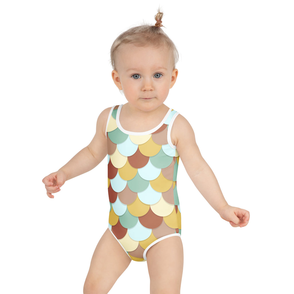 A toddler wearing a girls retro mermaid scales buttery soft swimsuit with upf 50 plus in pastel yellow mint green and brown
