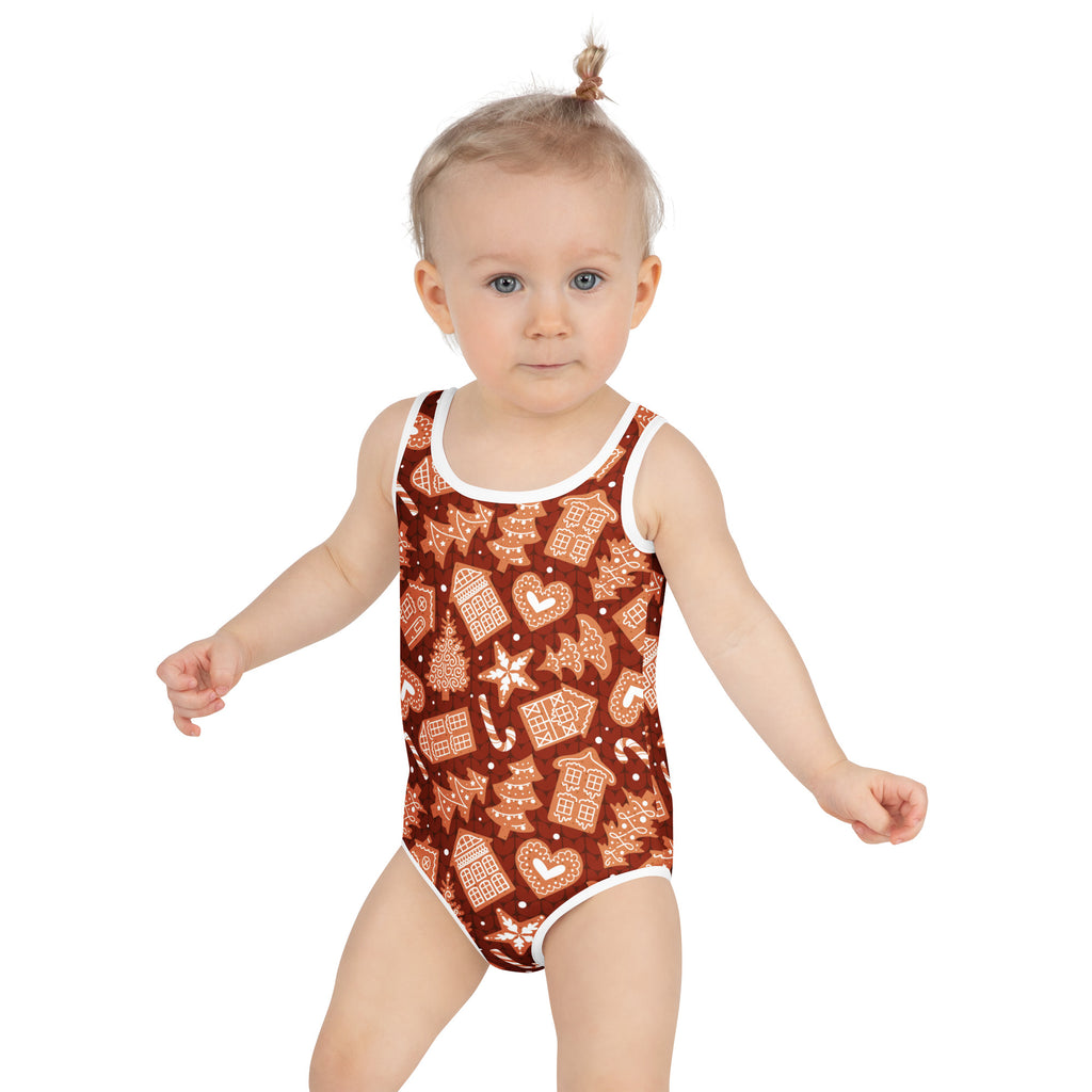 A girls brown one-piece swimsuit with white trim and gingerbread house holiday print buttery soft with upf 50+