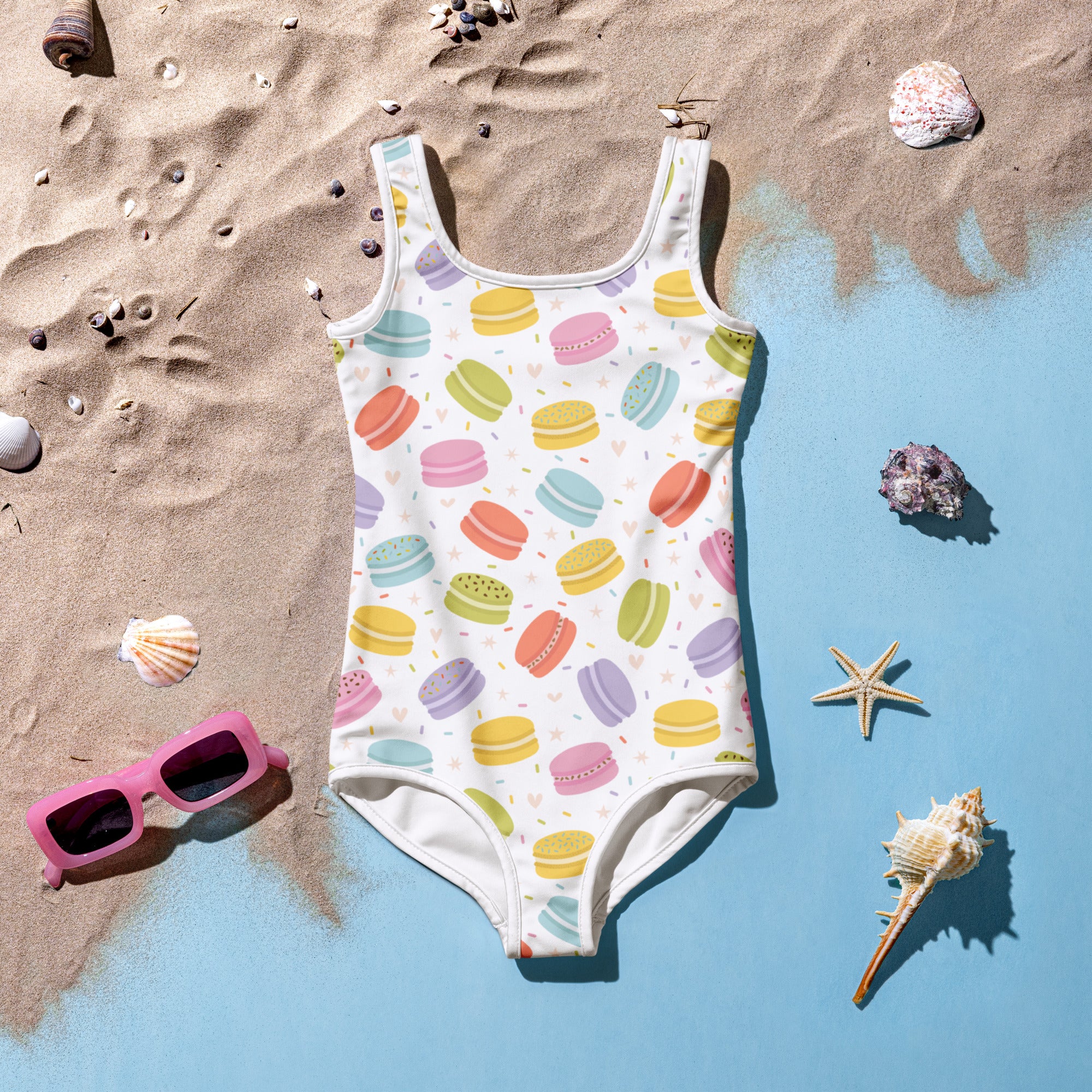 Girls pastel macaron one-piece swimsuit in white buttery soft fabric with colorful pastel macarons and UPF 50+ protection