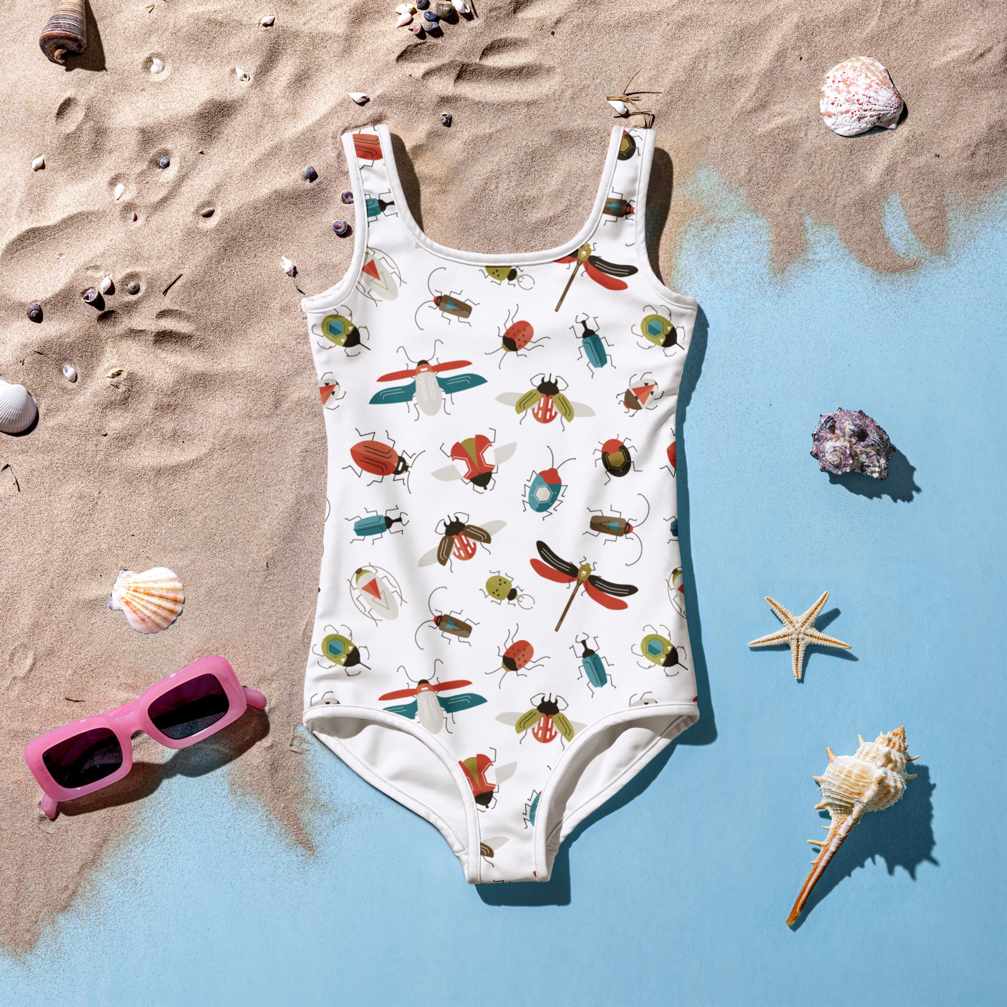 A white one-piece girls swimsuit with colorful insect and dragonfly pattern buttery soft fabric and upf 50+ protection