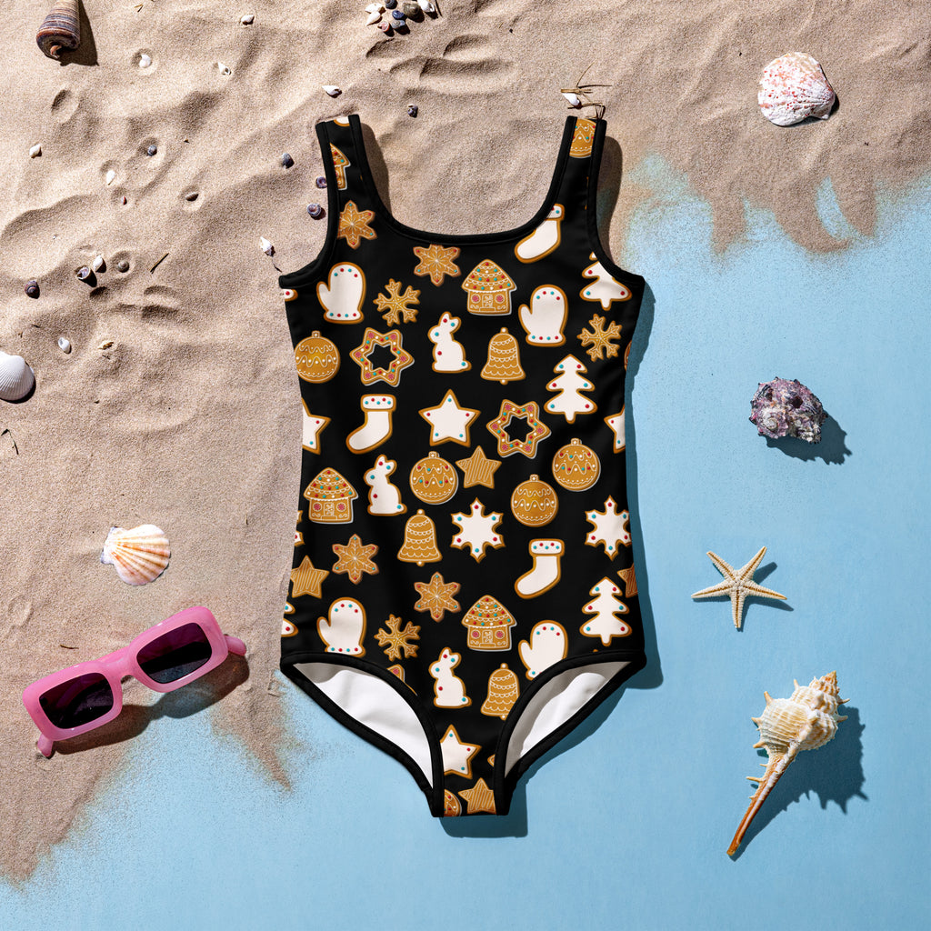 Girls black one-piece swimsuit with buttery soft fabric and festive gold and white gingerbread cookie pattern with UPF 50+