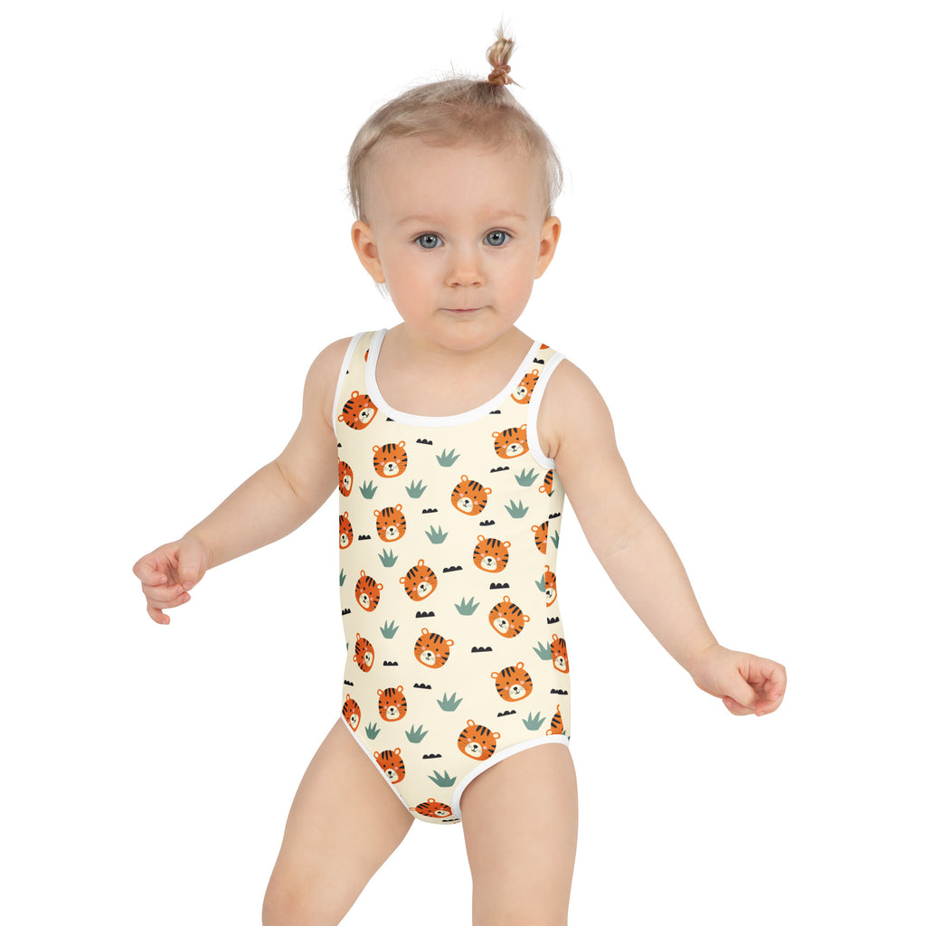 A child wearing a white girls tiger print buttery soft swimsuit with orange tiger faces green cactus and UPF 50+ protection