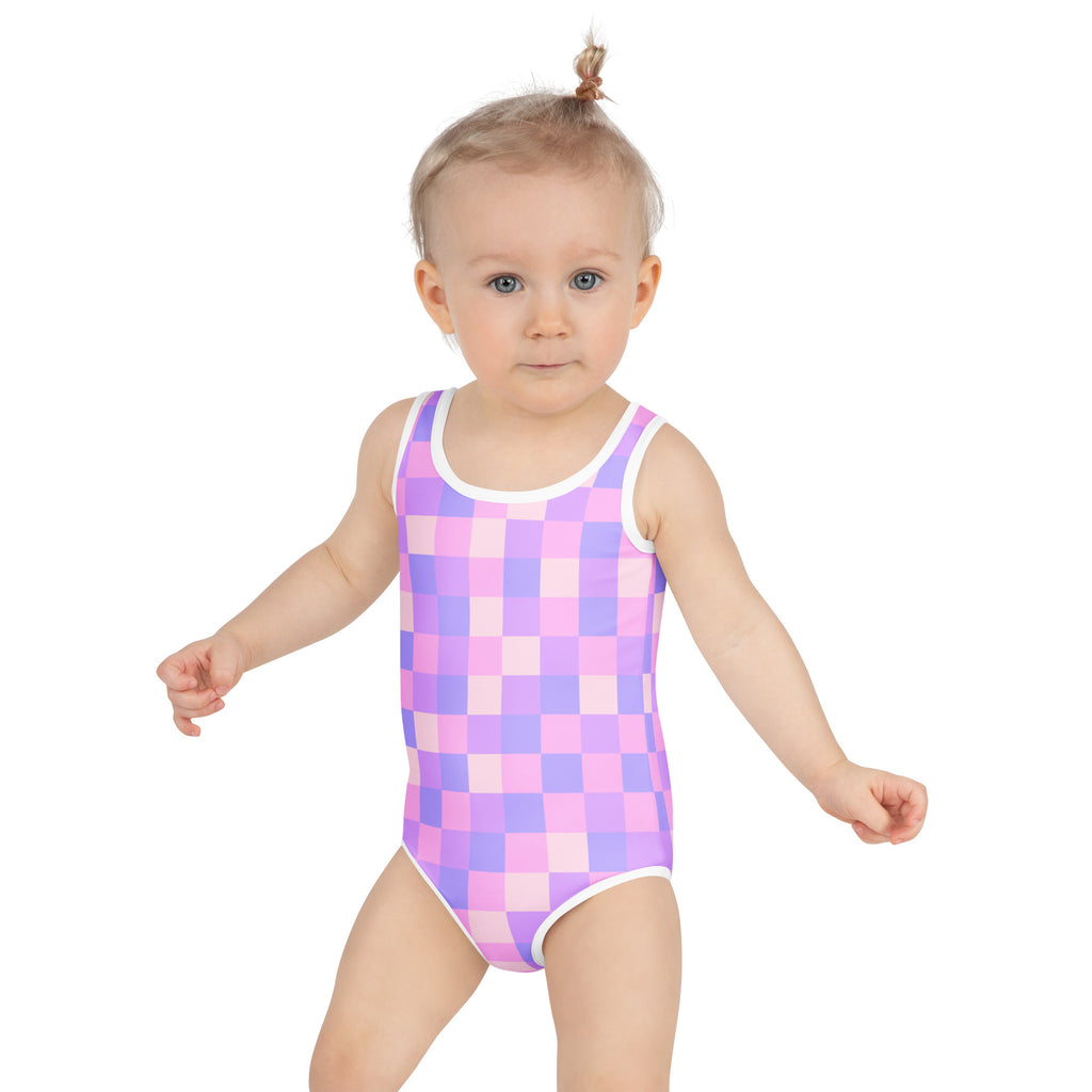 A toddler wearing a girls pastel purple checkered buttery soft swimsuit with UPF 50 plus and white trim