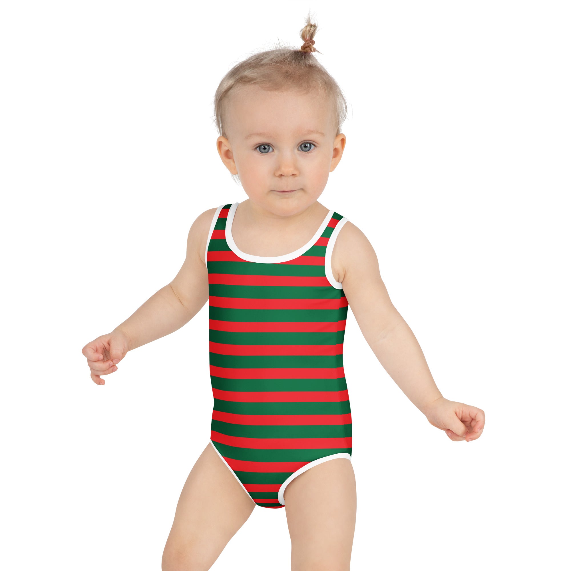 A toddler wearing a girls festive christmas stripes buttery soft red and green striped swimsuit with UPF 50+ protection