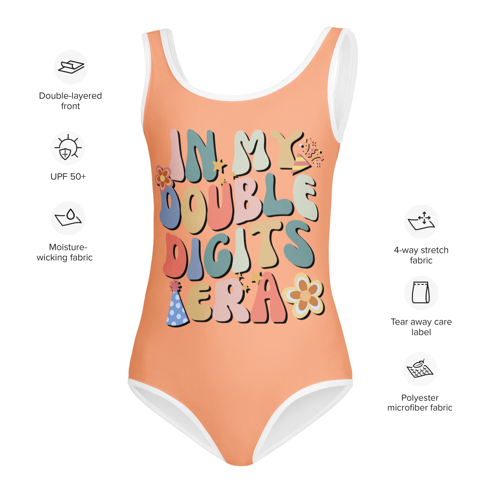 A peach-colored girls one-piece swimsuit with white trim and colorful in my double digits era graphic for gymnastics