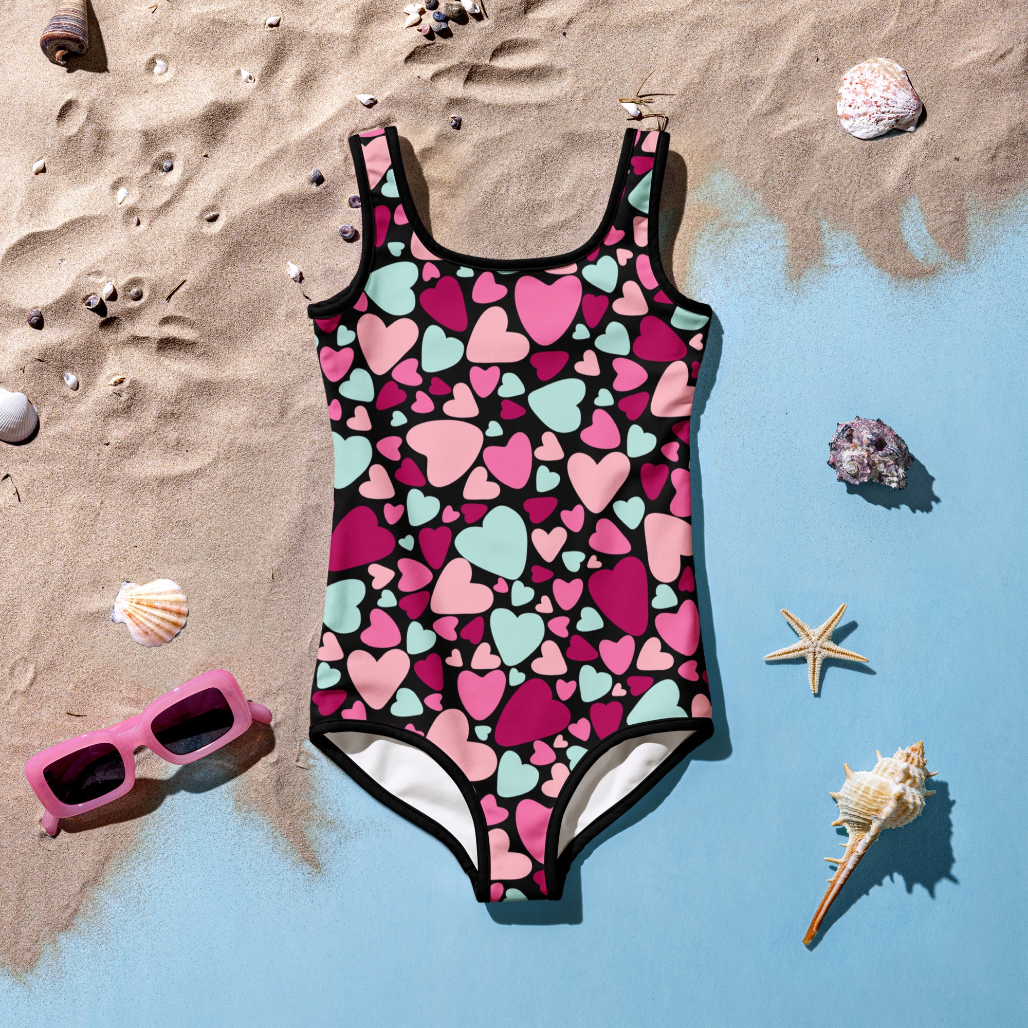 Girls Valentine’s Day one-piece swimsuit with pink and mint green hearts on black, white trim, buttery soft with UPF 50+ protection