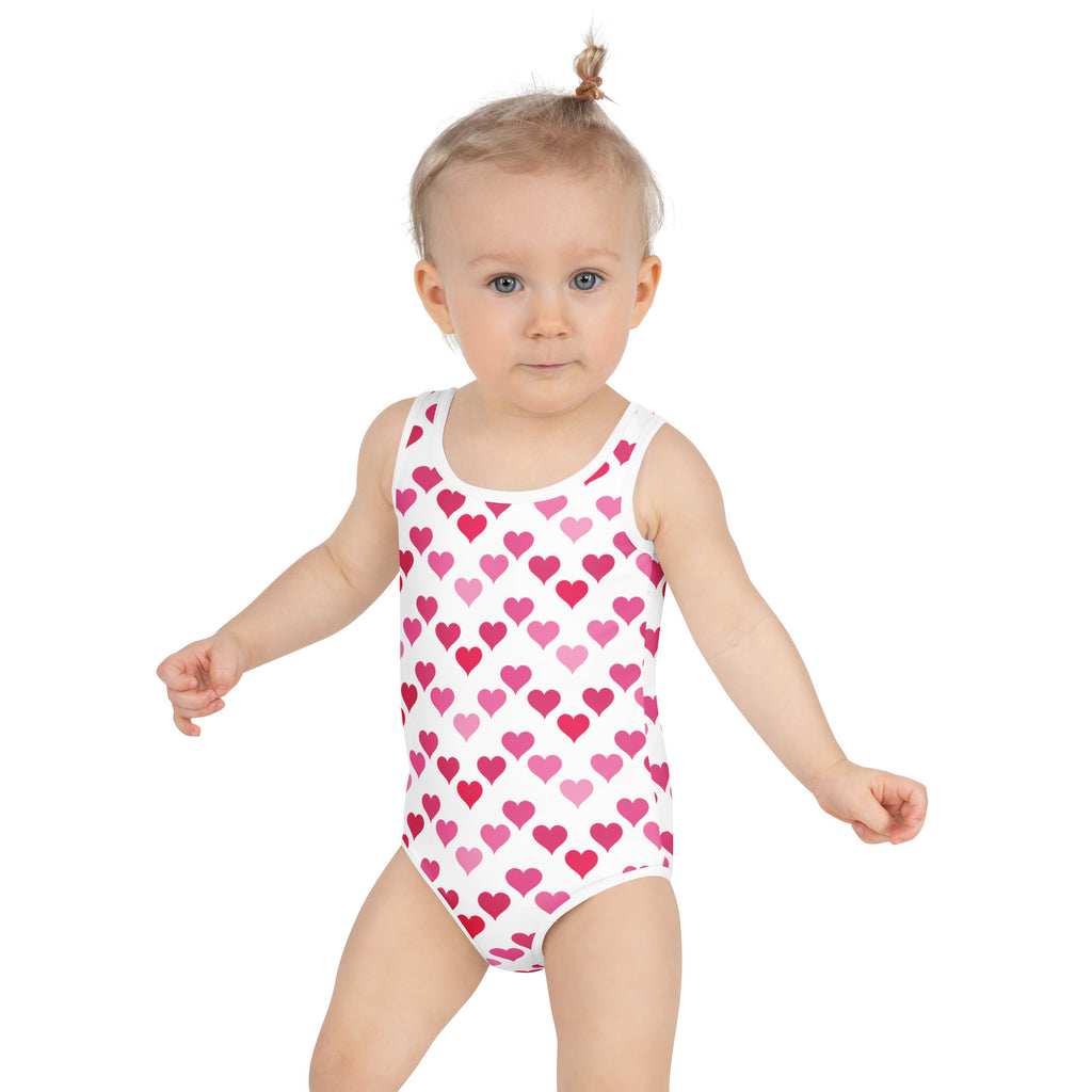 A white girls one-piece swimsuit with pink heart pattern buttery soft fabric and UPF 50 plus sun protection