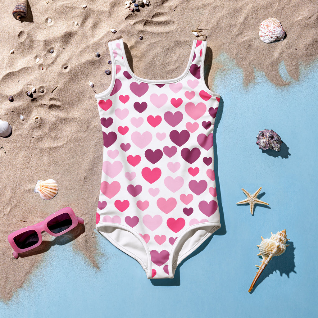 A white one-piece girls swimsuit with pink and purple hearts buttery soft with UPF 50 plus and double layered front